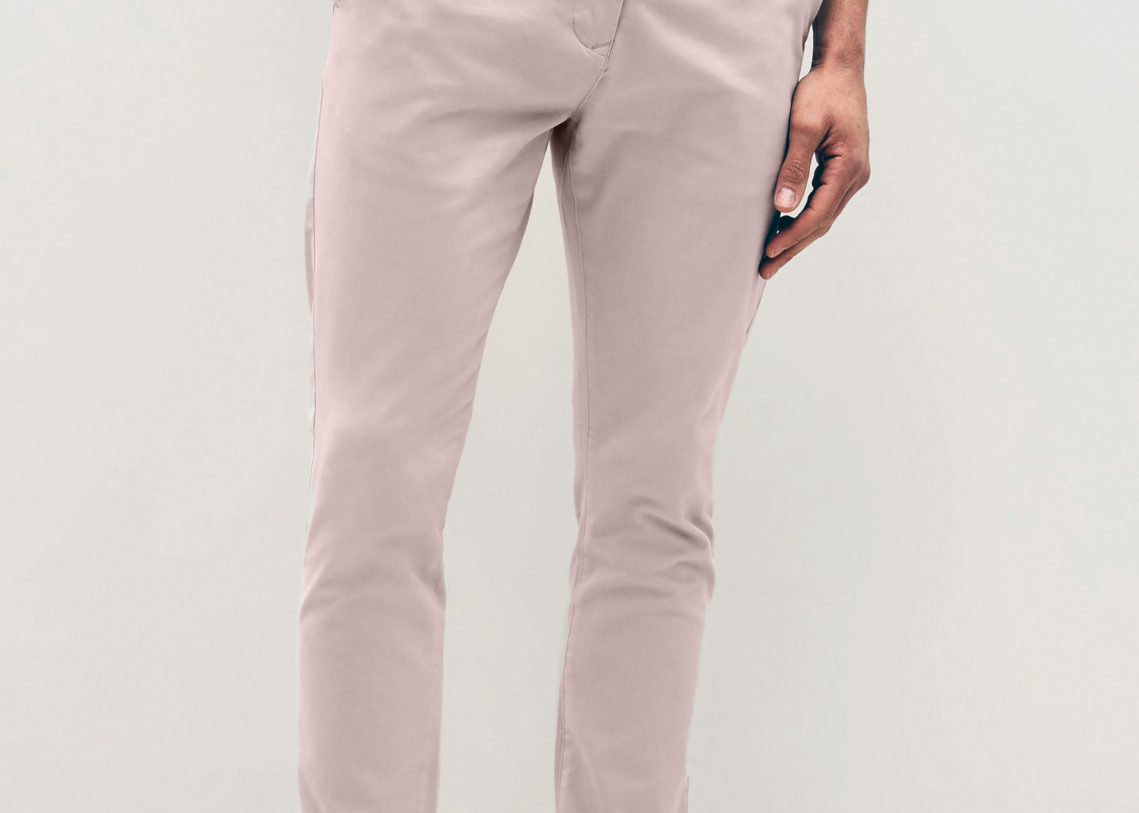 Mens pale pink chinos with front slanted pockets, jetted back pockets. zip fly fastening and brown horne buttons on the waistband and back pockets, the fit is a slim fit, this is worn with a white tee and white unbranded trainers