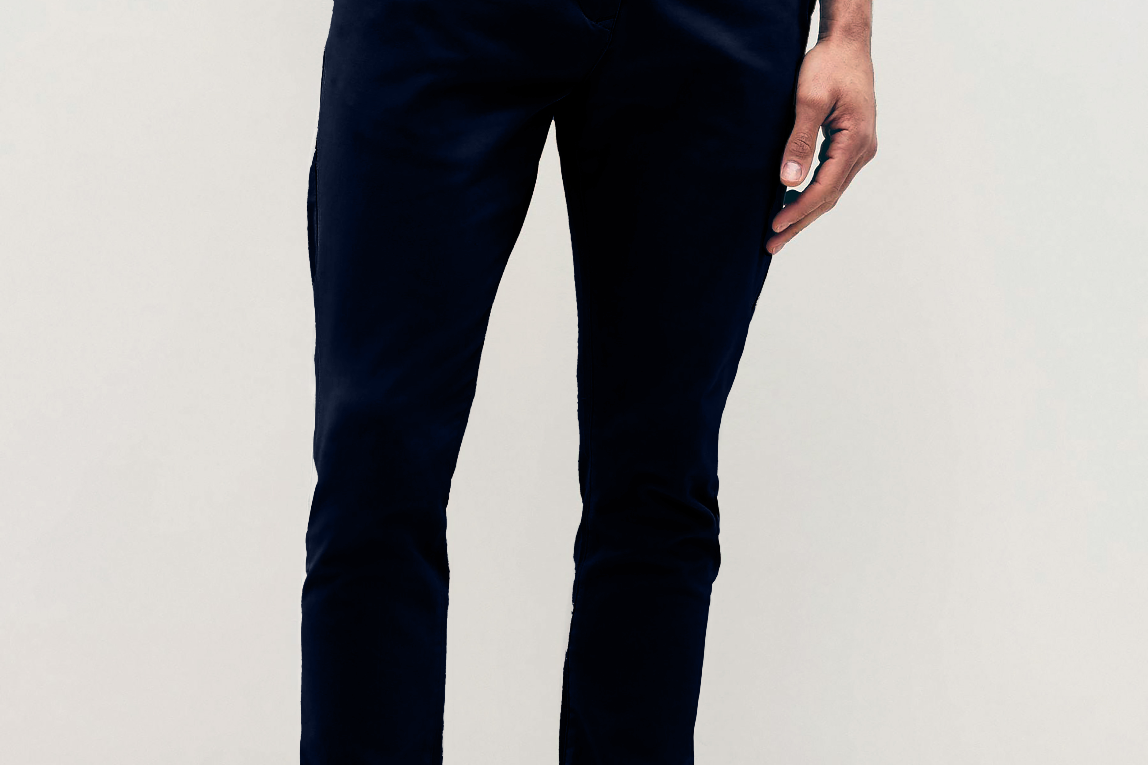 Mens Navy chinos with front slanted pockets, jetted back pockets. zip fly fastening and brown horne buttons on the waistband and back pockets, the fit is a slim fit, this is worn with a white tee and white unbranded trainers