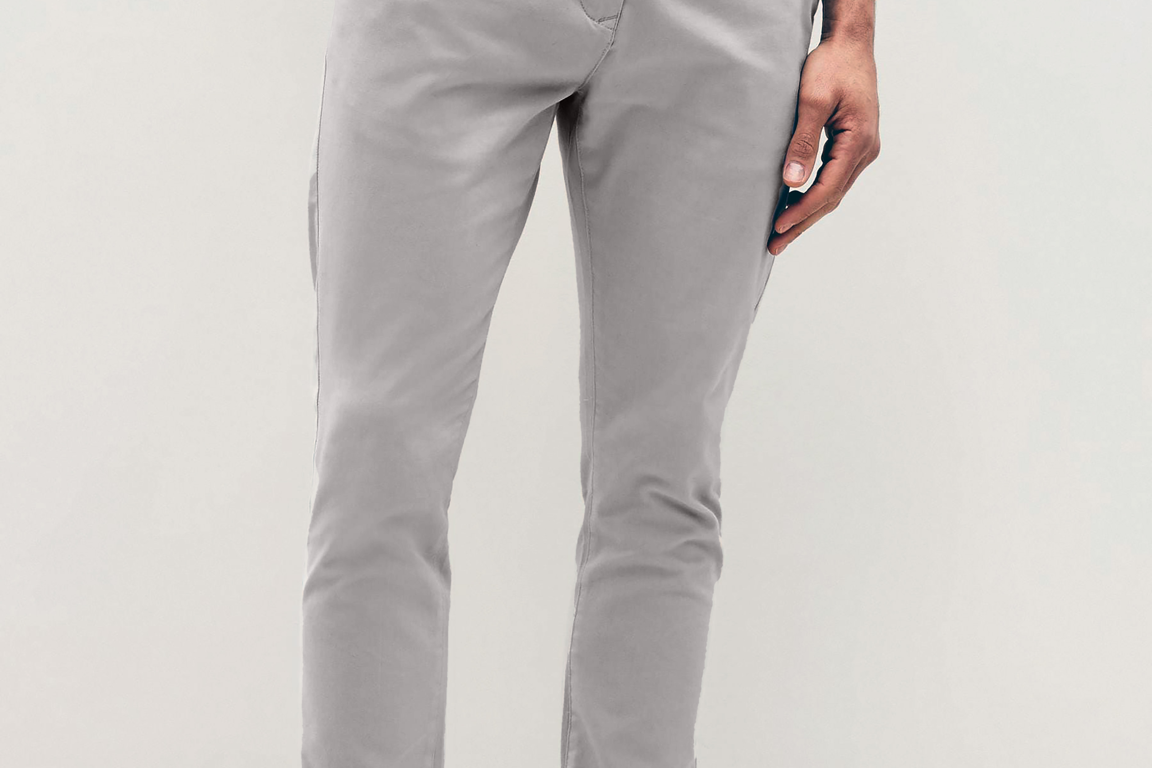 Mens Silver Grey chinos with front slanted pockets, jetted back pockets. zip fly fastening and brown horne buttons on the waistband and back pockets, the fit is a slim fit, this is worn with a white tee and white unbranded trainers