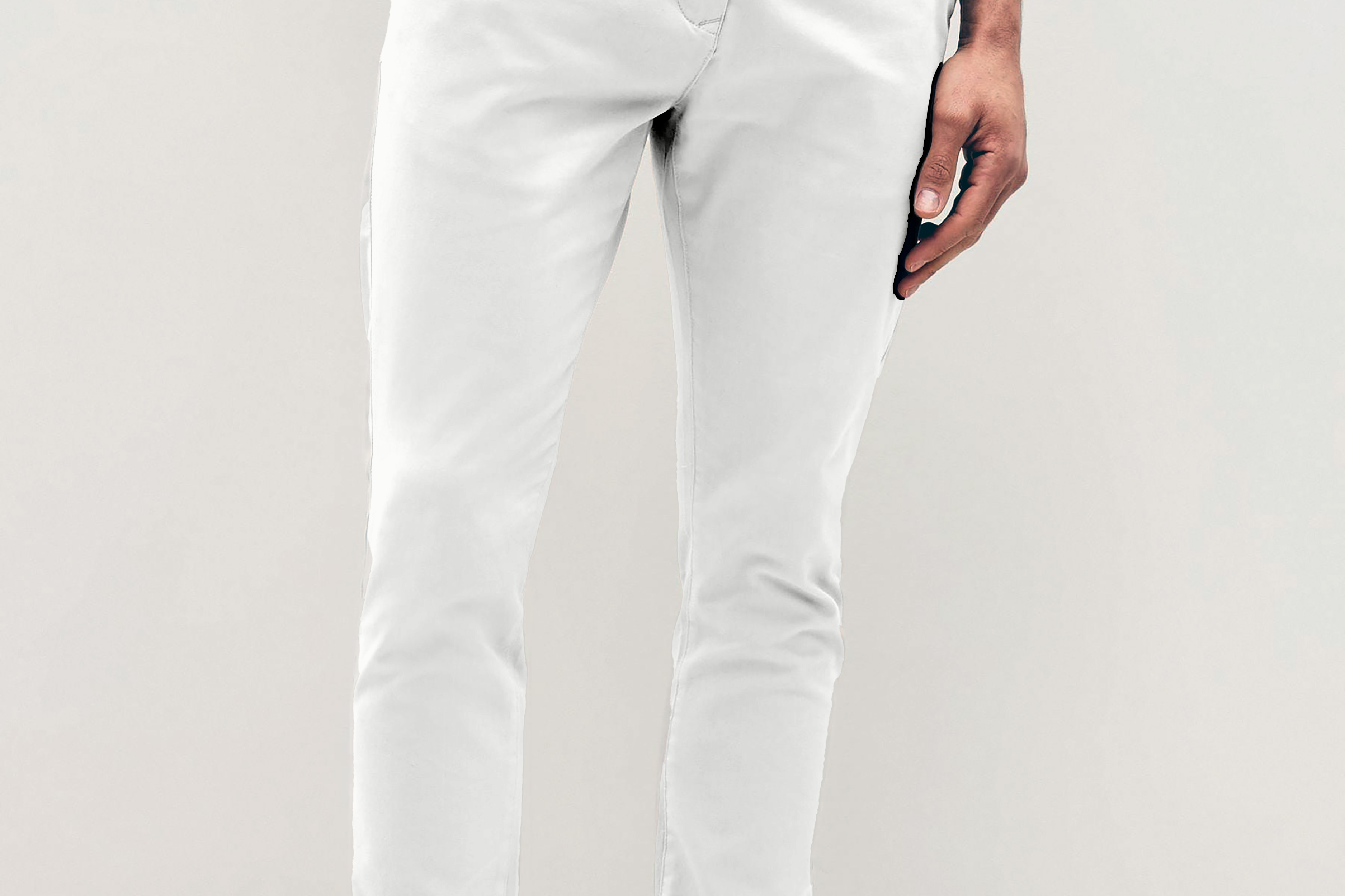 Mens white chinos with front slanted pockets, jetted back pockets. zip fly fastening and brown horne buttons on the waistband and back pockets, the fit is a slim fit, this is worn with a white tee and white unbranded trainers