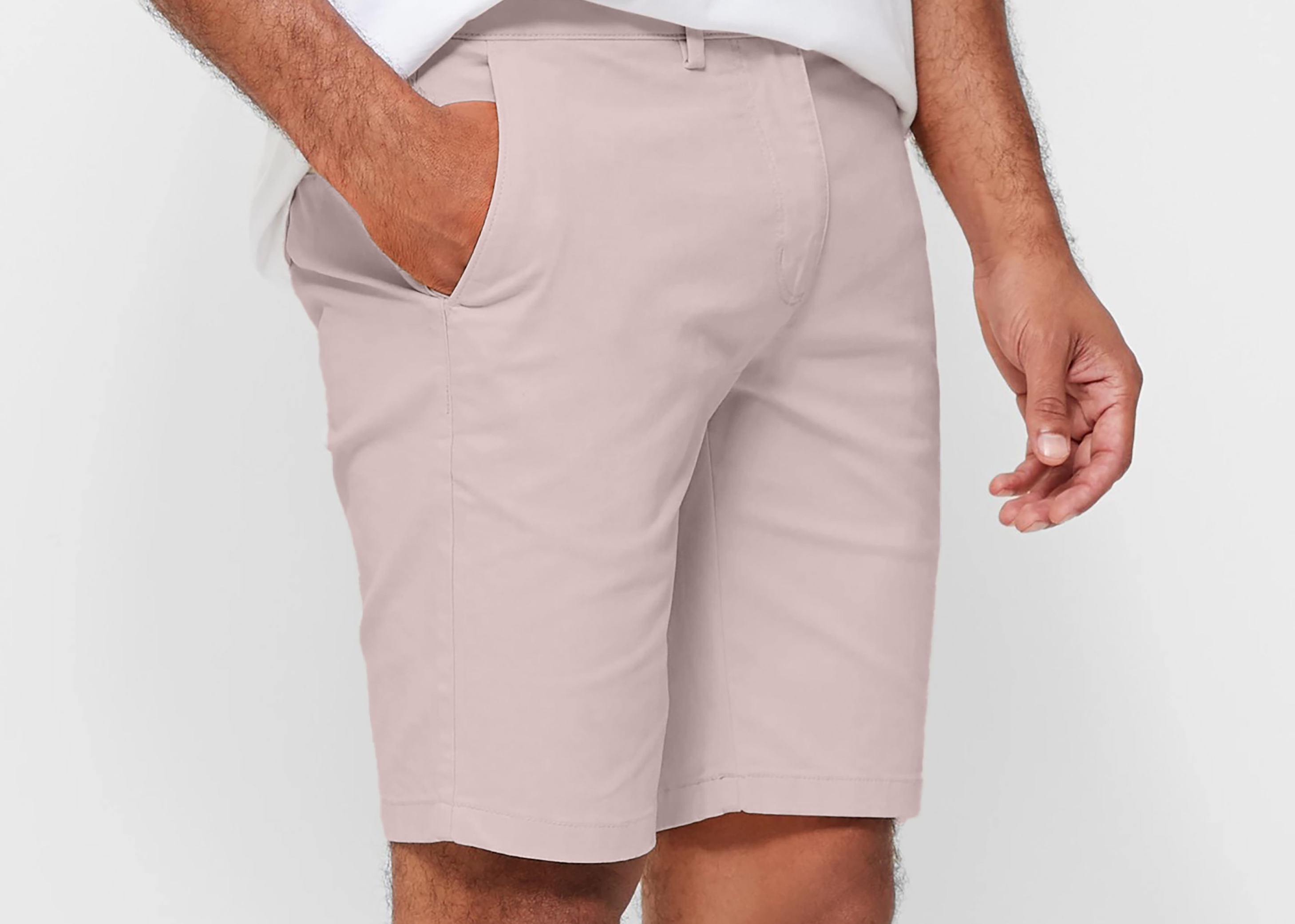 Mens pale pink chinos shorts with front slanted pockets, jetted back pockets. zip fly fastening and brown horne buttons on the waistband and back pockets, the fit is a slim fit, this is worn with a white tee and white t-shirt