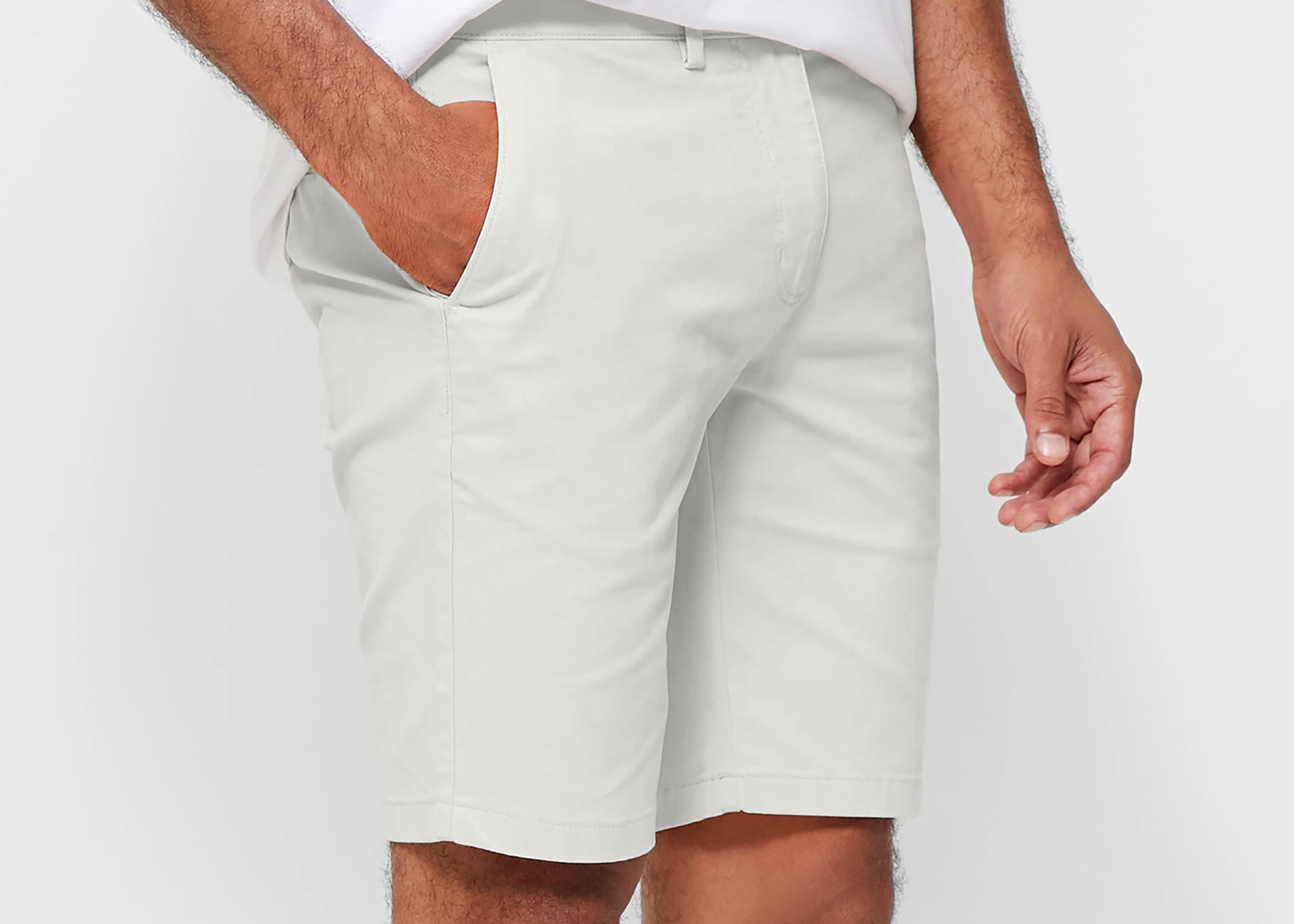 Mens White chinos shorts with front slanted pockets, jetted back pockets. zip fly fastening and brown horne buttons on the waistband and back pockets, the fit is a slim fit, this is worn with a white tee and white t-shirt